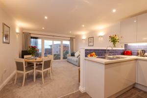 a kitchen and living room with a table and a couch at Beachcombers Apartments in Newquay