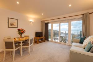 a living room with a table and a couch at Beachcombers Apartments in Newquay