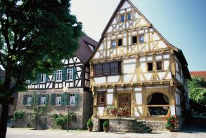 an old house with green shuttered windows at Hotel Restaurant Zum Nachtwächter in Lienzingen