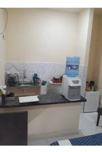 a kitchen with a sink and a microwave on a counter at Suite no Centro Wi-Fi DISP in Boa Vista