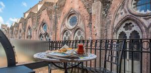 a table on a balcony in front of a church at Art Hotel Commercianti in Bologna