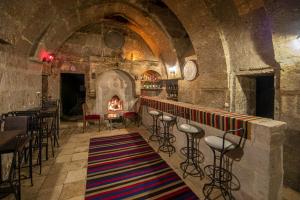 a bar in a stone building with a fireplace at Kapadokya Ihlara Konakları Otel Konak Odaları in Guzelyurt