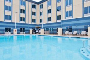 a large swimming pool in front of a building at Holiday Inn Express & Suites Warner Robins North West, an IHG Hotel in Warner Robins