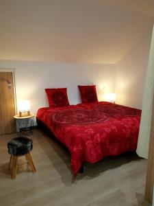 1 dormitorio con 1 cama roja y 2 almohadas rojas en appart l'Écureuil 4 étoiles en Cornimont