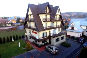a house with a suv parked in front of it at Willa Florynka in Biały Dunajec