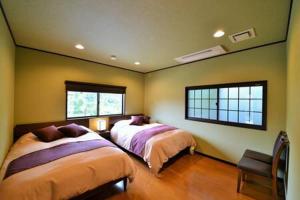 - 2 lits dans une chambre avec 2 fenêtres dans l'établissement Ohara Sensui Surrounded by Beautiful Nature, à Kyoto