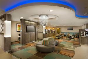 a lobby with a waiting room with chairs and a television at Holiday Inn Express Hotel and Suites DFW-Grapevine, an IHG Hotel in Grapevine