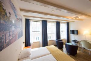 een hotelkamer met een groot bed en ramen bij Hotel Residence Le Coin in Amsterdam