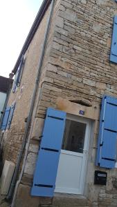 a door on a brick building with blue shutters at Gîte La P'tite Louise in Les Riceys