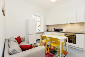a kitchen with a couch and a table and chairs at Arida Apartments in Rīga