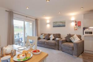 a living room with a couch and a table at Beachcombers Apartments in Newquay