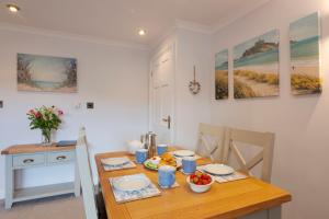 a kitchen with a wooden table with food on it at Beachcombers Apartments in Newquay