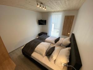 a bedroom with a large bed with white pillows at Ferienwohnung Preisinger in Oberammergau
