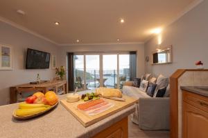 a kitchen with a table with fruits and vegetables on it at Beachcombers Apartments in Newquay