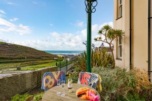 a table and chairs with a view of the ocean at Beachcombers Apartments in Newquay