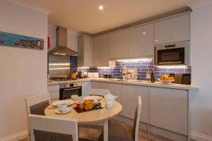 a kitchen with a table with a bowl of fruit on it at Beachcombers Apartments in Newquay