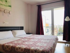 1 dormitorio con cama y ventana grande en Apartamentos Turísticos Yamasol, en Fuengirola