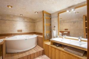 baño grande con bañera y espejo grande en Luxurious flat w sauna in L'Alpe d'Huez - Welkeys, en LʼHuez