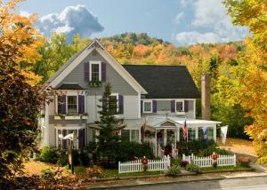 a white house with a white fence at Phineas Swann Inn & Spa in Montgomery Center