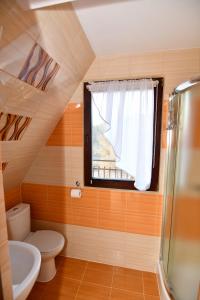 a small bathroom with a toilet and a window at Willa Florynka in Biały Dunajec