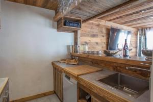 cocina con encimera de madera, fregadero y encimera en Luxurious flat w sauna in L'Alpe d'Huez - Welkeys, en LʼHuez