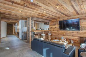 sala de estar con sofá y TV de pantalla plana en Luxurious flat w sauna in L'Alpe d'Huez - Welkeys, en LʼHuez