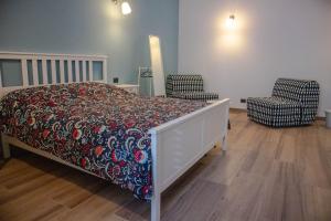 Un dormitorio con una cama y dos sillas. en La Casa dei Nonni, en Trani