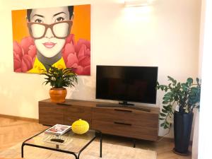 a living room with a television and a painting at Opera Luxury Rosmini in Rome