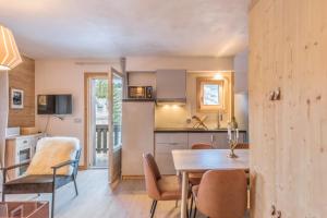 a kitchen and dining room with a table and chairs at Appartement Hibou - Welkeys in Megève