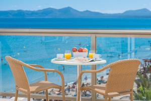 a table with a plate of food and two chairs at Aparthotel Ses Fotges in Playa de Muro