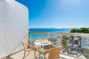 a balcony with a table and chairs and a view of the beach at Aparthotel Ses Fotges in Playa de Muro