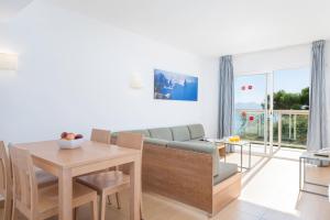a living room with a couch and a table at Aparthotel Ses Fotges in Playa de Muro