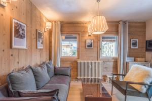 a living room with a couch and a table at Appartement Hibou - Welkeys in Megève