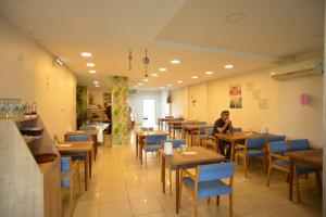 a woman sitting at a table in a restaurant at Yeşilyurt Pansiyon Hotel in İzmir