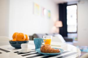 a table with a plate of food and a glass of orange juice at Oceanográfico Apartments in Valencia