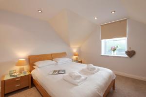 a bedroom with a bed and a window with towels at Beachcombers Apartments in Newquay