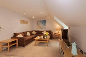 a living room with a couch and a tv at Beachcombers Apartments in Newquay