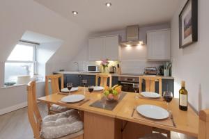a kitchen with a wooden table with glasses of wine at Beachcombers Apartments in Newquay