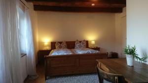 a bedroom with a bed with two pillows and a table at Pension Müllers Mühle in Großenhain
