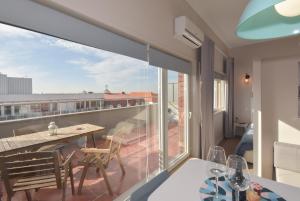 Una habitación con balcón con mesa y sillas. en Alexandre Herculano Oporto Residence I II & III, en Oporto