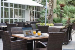 an outdoor table with a laptop on top of it at Aparthotel Ses Fotges in Playa de Muro