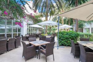 an outdoor restaurant with tables and chairs and umbrellas at Aparthotel Ses Fotges in Playa de Muro