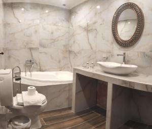 uma casa de banho com um lavatório, um WC e um espelho. em Aloni Toy Kir Thanasi Hotel & Spa em Volakas