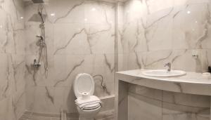 a white bathroom with a toilet and a sink at Aloni Toy Kir Thanasi Hotel & Spa in Volakas