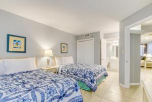 a bedroom with two beds with blue and white sheets at Hosteeva Ocean Forest Plaza w Beachview Balcony in Myrtle Beach