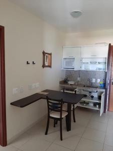 a kitchen with a table and a chair in a room at Elegance Suítes Beira Mar in Natal