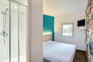 a bedroom with a shower, a bed, and a window at hotelF1 Mulhouse Bâle Aéroport in Haberhaeuser