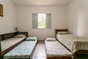 Habitación con 2 camas y ventana en Casa em meio a natureza, em frente ao canal, en Florianópolis