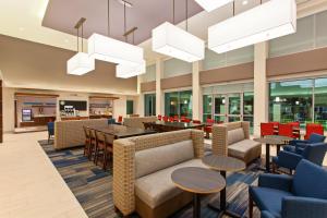 um lobby de um hospital com mesas e cadeiras em Holiday Inn Express & Suites Houston S - Medical Ctr Area, an IHG Hotel em Houston