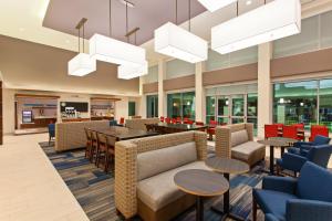 a lobby of a hospital with tables and chairs at Holiday Inn Express & Suites Houston S - Medical Ctr Area by IHG in Houston